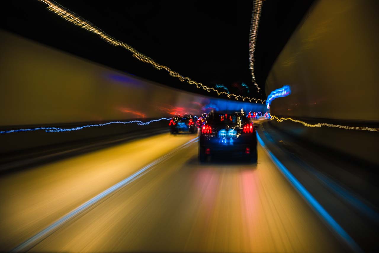 High-Speed Driving and Traffic Offenses in Rhode Island Vehicles speeding through a tunnel at night with motion blur, symbolizing high-speed and reckless driving offenses.