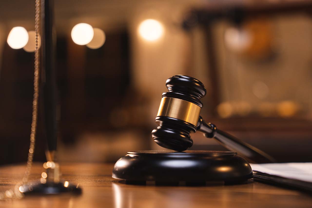 Understanding Misdemeanor Charges in Rhode Island Gavel on a courtroom table with blurred legal books in the background, symbolizing misdemeanor court proceedings.